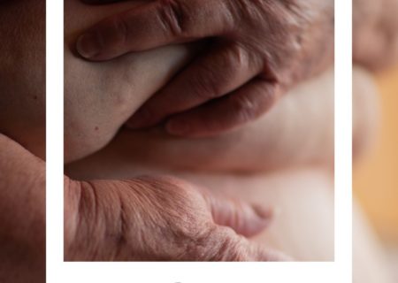 An older white woman's hands grasping her belly rolls. A faux polaroid frame is on top with today's word written on the frame.