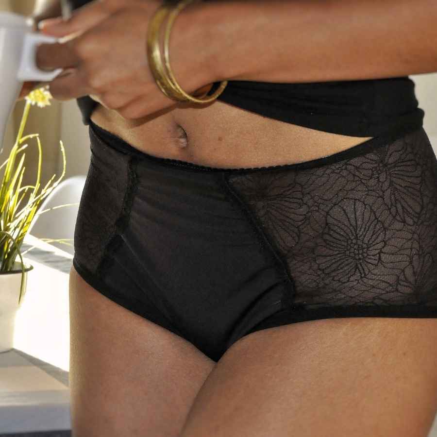 A Black woman wearing black lacey panties