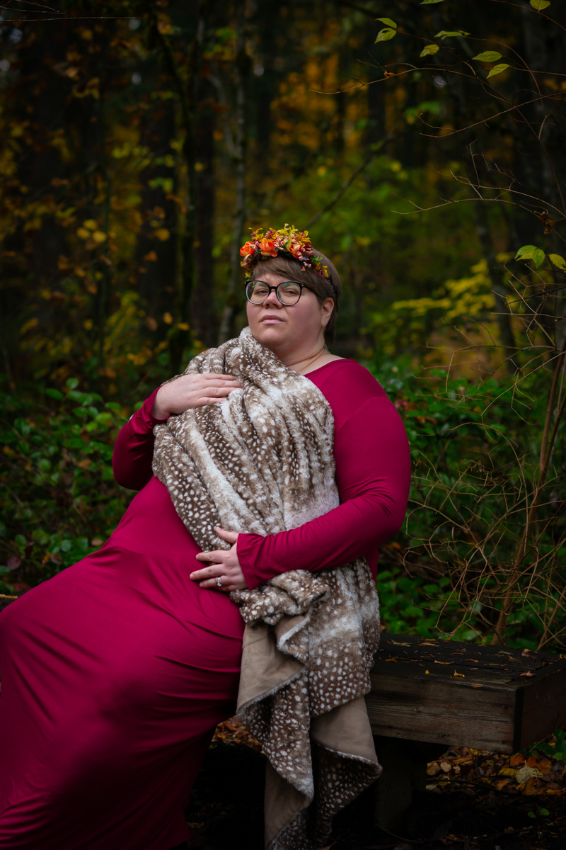 A woman at a body-positive maternity photoshoot outdoors in the Pacific Northwest. 