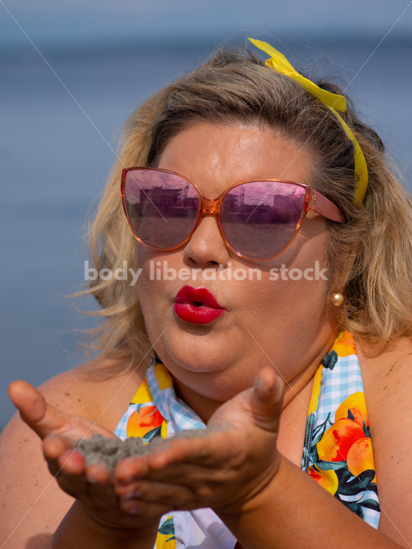 Body-Positive Stock Photo: Plus Size Woman Blows on Sand in Front of the Ocean - It's time you were seen ⟡ Body Liberation Photos