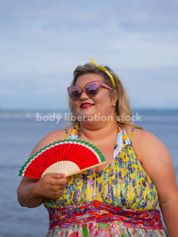 Body-Positive Stock Photo: Plus Size Woman Poses in Front of the Ocean with a Watermelon Fan Smiling Contently - It's time you were seen ⟡ Body Liberation Photos