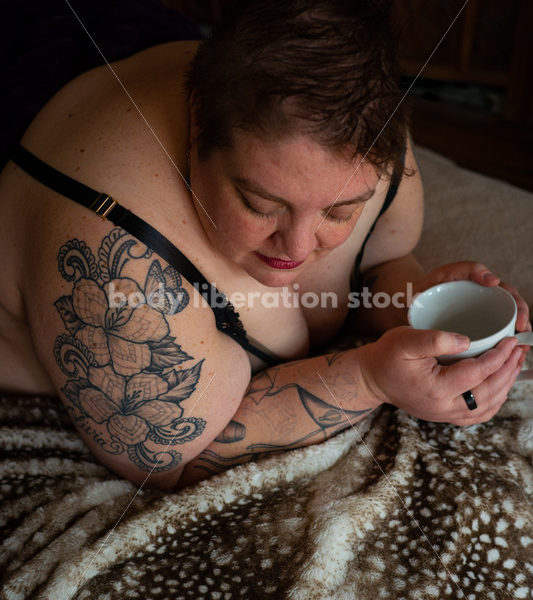 Body-Positive Stock Photo: Plus Size Woman Relaxing on Soft Blankets Holding a Cup - Body Liberation Photos