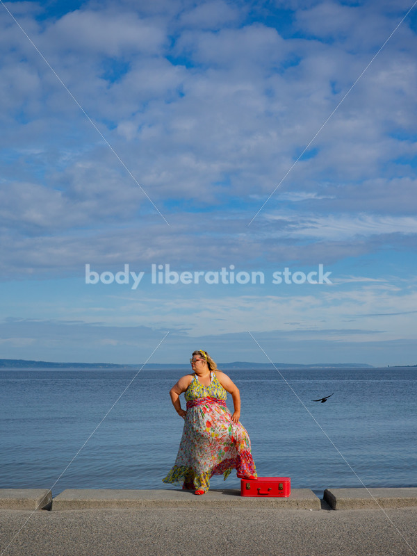 Body-Positive Stock Photo: Plus Size Woman Stands by the Ocean with One Foot on a Red Suitcase - It's time you were seen ⟡ Body Liberation Photos