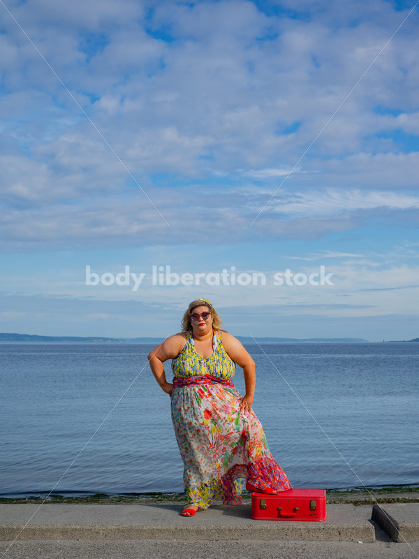 Body-Positive Stock Photo: Plus Size Woman Stands by the Ocean with One Foot on a Red Suitcase - It's time you were seen ⟡ Body Liberation Photos