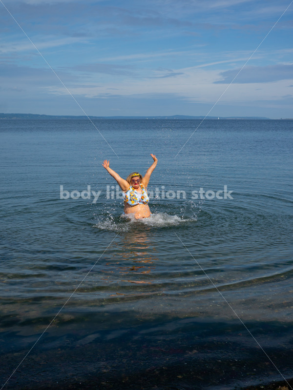 Body-Positive Stock Photo: Plus Size Woman in a Blue Swimsuit Splashes Freely in the Ocean - It's time you were seen ⟡ Body Liberation Photos