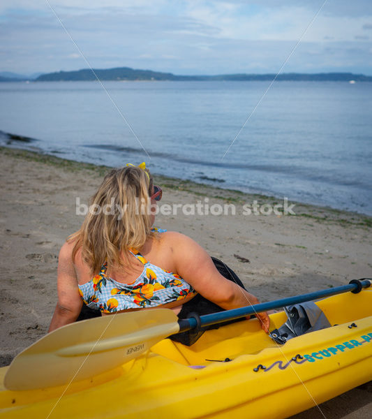 Body-Positive Stock Photo: Plus Size Woman in a Blue Swimsuit and Skirt Coverup Looking Over the Water - Body Liberation Photos & Stock