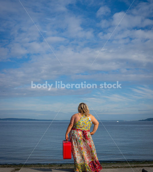 Body-Positive Stock Photo: Plus Size Woman on the Beach Holding a Red Suitcase - Body Liberation Photos & Stock