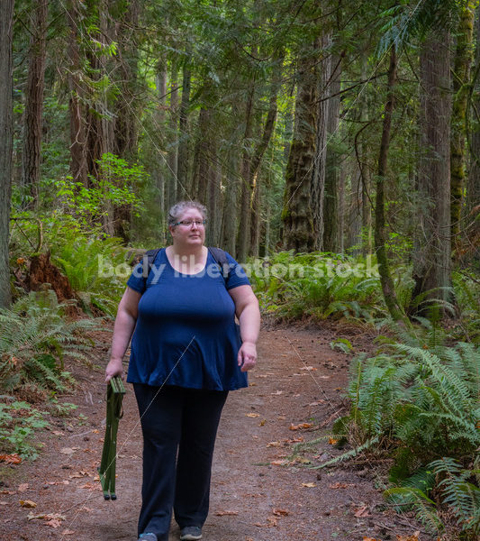 Plus Size Woman Hikes on a Trail in the Woods Carrying a Stool (facing the camera) - It's time you were seen ⟡ Body Liberation Photos