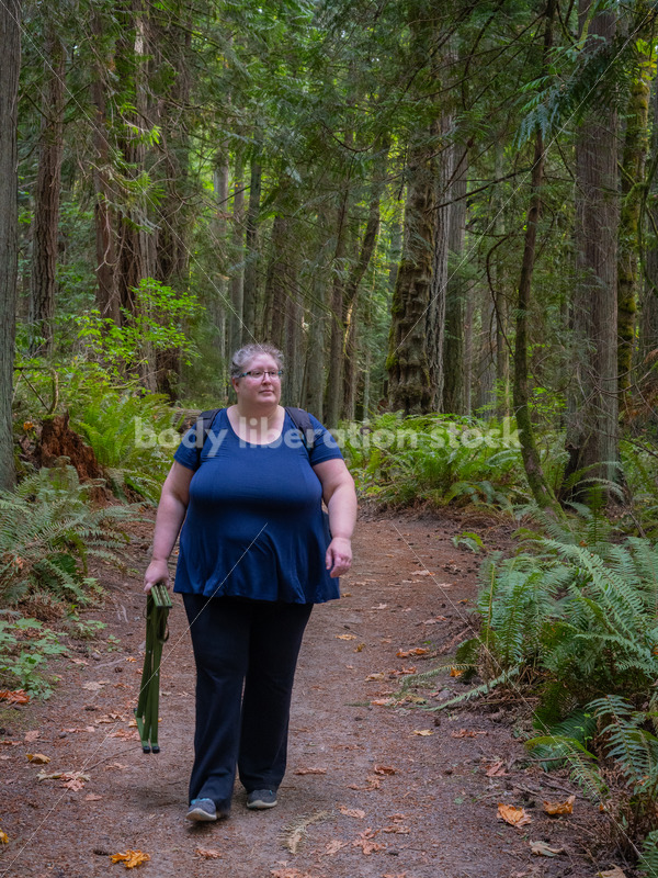 Plus Size Woman Hikes on a Trail in the Woods Carrying a Stool (facing the camera) - It's time you were seen ⟡ Body Liberation Photos