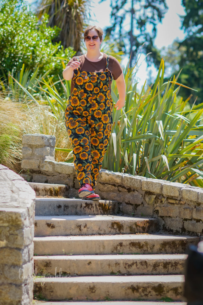 A non-binary person with short hair and casual clothes strolls jauntily down a set of a steps at a park in Seattle at an outdoor business branding session.