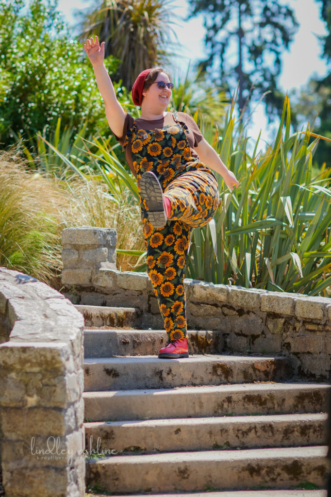A non-binary person with short hair and casual clothes strolls jauntily down a set of a steps at a park in Seattle at an outdoor business branding session.